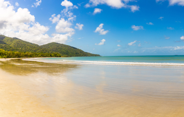 Спокойные волны на песке под красивым голубым небом