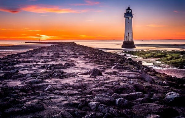 Каменная дорога ведет к маяку у моря