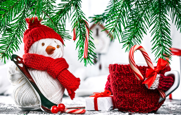 Снеговик из ниток на столе с чашкой и елочными ветками