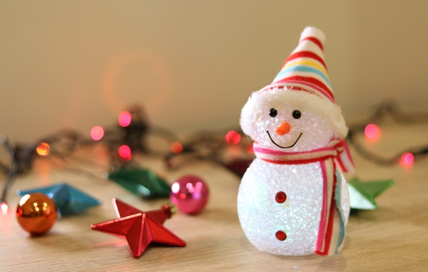 Снеговик с новогодними игрушками на столе