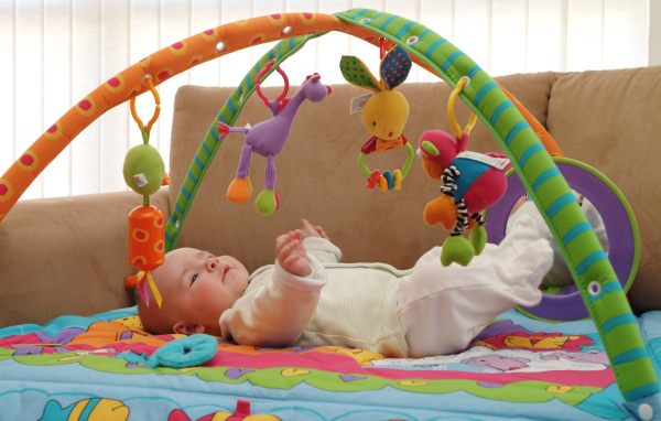 Грудной малыш играет с игрушками