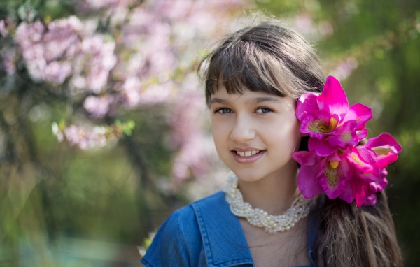 Красивая девочка с розовыми цветами в волосах