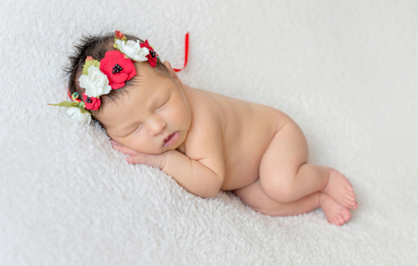 Грудная спящая девочка с венком на голове 