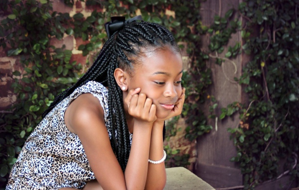 Темнокожая девочка с косичками на голове