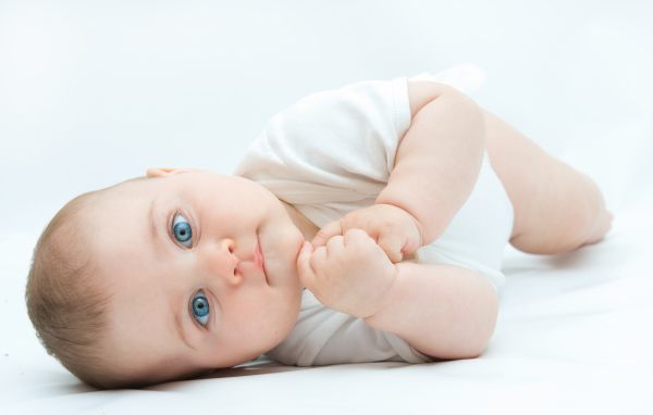 Забавный голубоглазый малыш на белом фоне