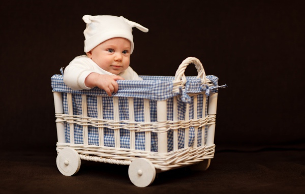 Маленький ребенок в кроватке на колесах 