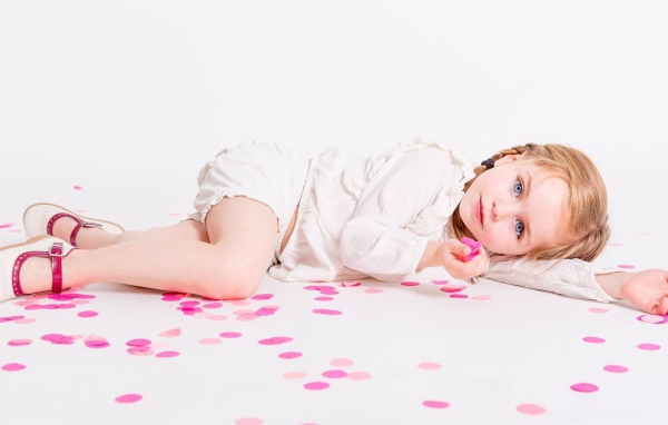 Маленькая голубоглазая девочка лежит на полу