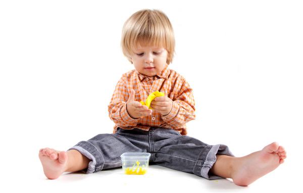 Маленький мальчик с игрушкой на белом фоне