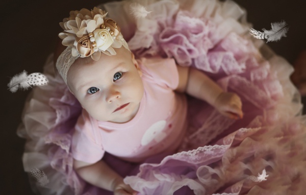 Маленькая милая девочка в пышном платье с повязкой на голове