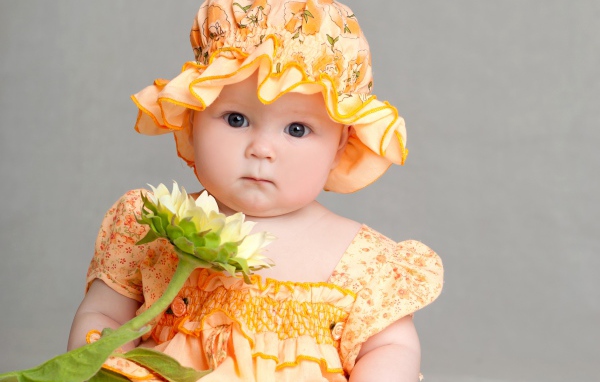 Маленькая девочка в красивом наряде с цветком