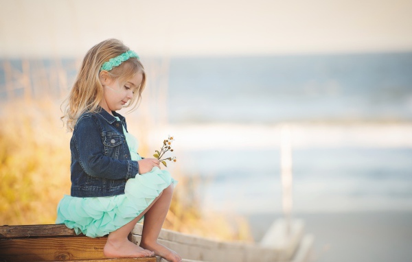 Маленькая девочка сидит на мосту