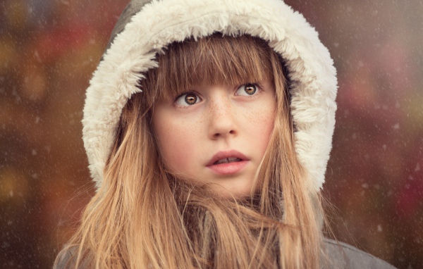 Маленькая девочка с веснушками на лице в капюшоне 