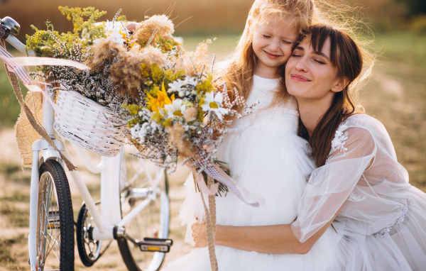 Маленькая девочка с мамой у велосипеда