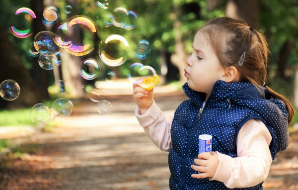 Маленькая девочка  с мыльными пузырями 