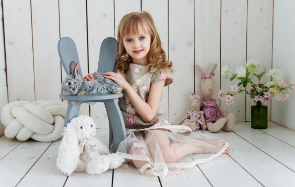 Маленькая девочка с игрушками в комнате сидит на полу