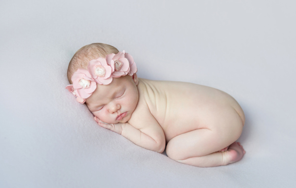 Спящая девочка с розовым венком на голове