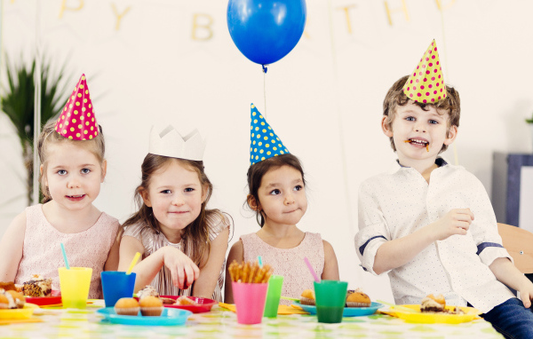 Маленькие дети отмечают детский праздник за столом