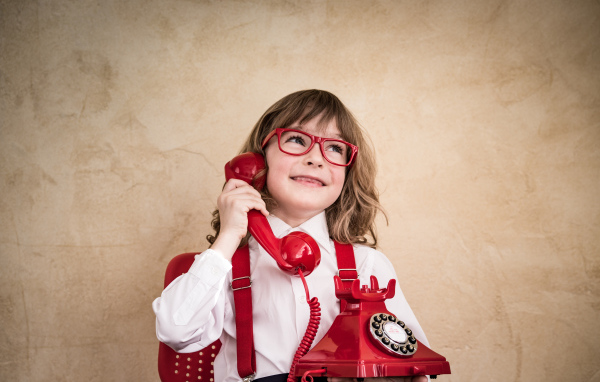 Улыбающийся мальчик с красным телефоном