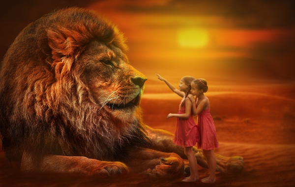 Две маленьких девочка тянут руку к большому льву