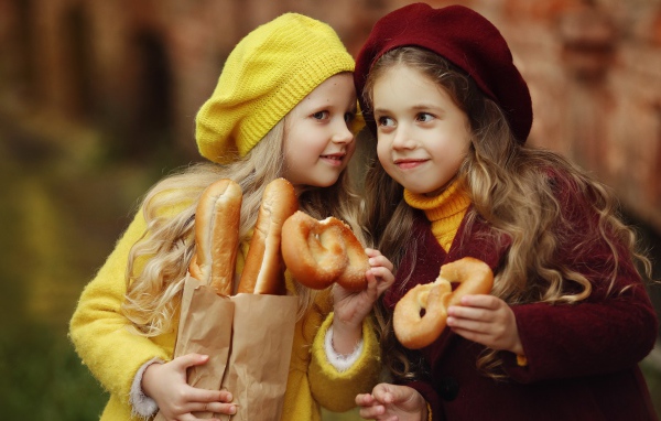 Две маленькие девочки с булочками 