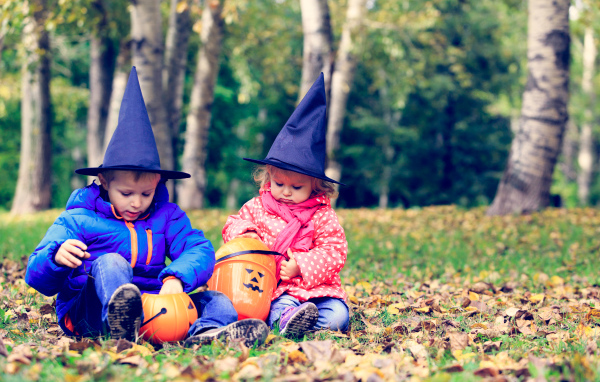 Маленькие мальчик и девочка в лесу на Хэллоуин 