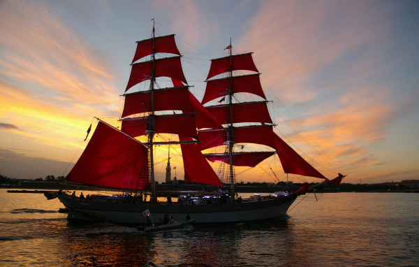 Большой корабль с алыми парусами на фоне заката