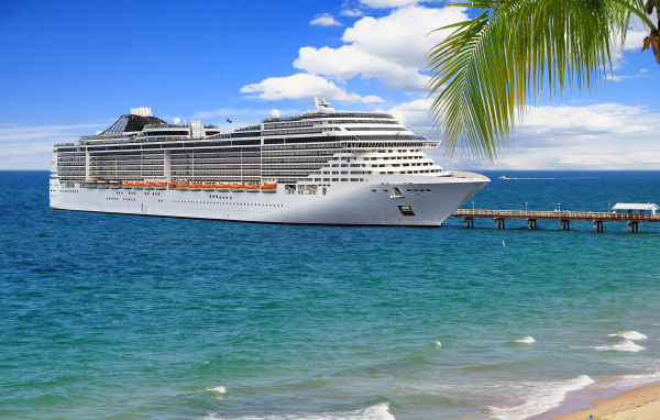 Large white cruise liner at the pier on a tropical beach