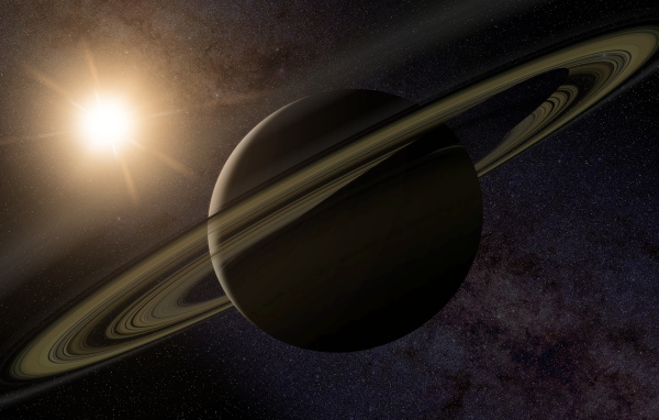 Планета Сатурн с кольцами на фоне солнца