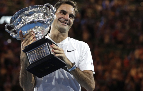 Улыбающийся швейцарский теннисист Роджер Федерер с наградой в руках