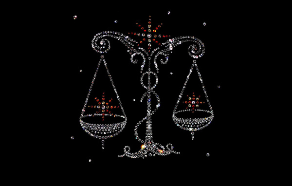 Блестящий знак зодиака весы на черном фоне