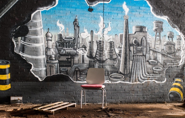 Стул стоит у кирпичной стены с граффити