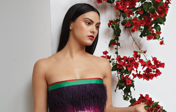 Актриса Камила Мендес стоит у стены с цветами