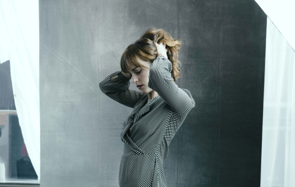 Актриса Дакота Джонсон в платье с руками в волосах