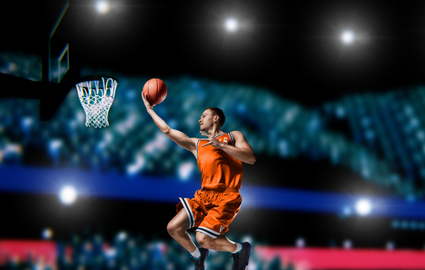 Парень баскетболист бросает мяч в кольцо