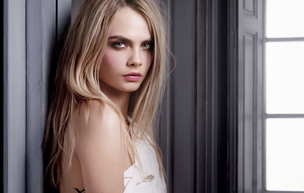 Красивая девушка, актриса Кара Делевинь у стены