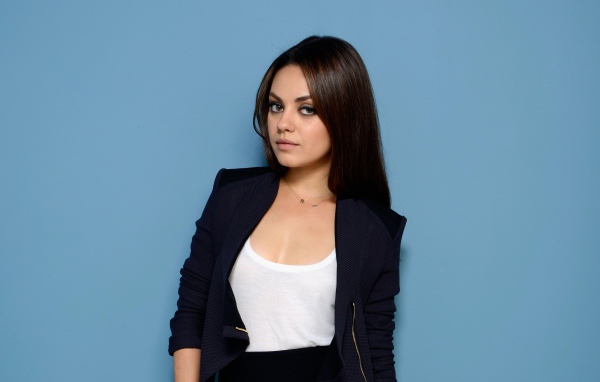 Красивая стильная актриса Мила Кунис на голубом фоне