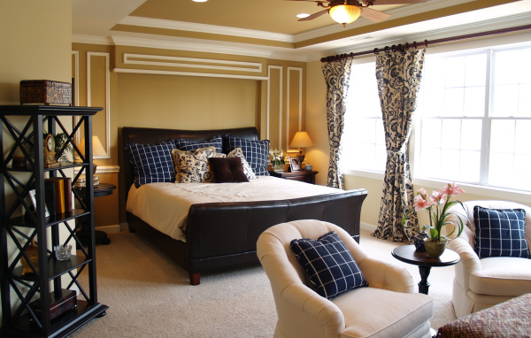 Спальня с большой кожаной кроватью и креслами 