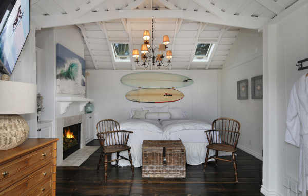 Спальня с большой белой кроватью и камином 