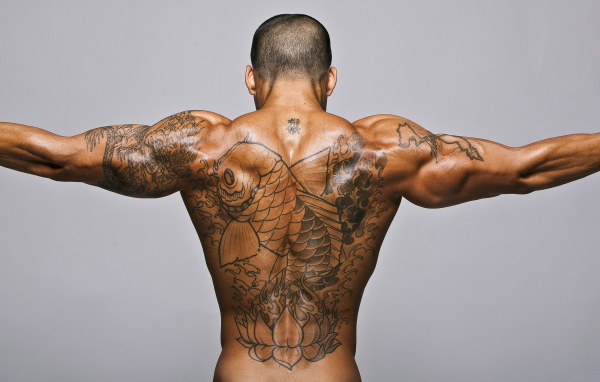Большая татуировка с рыбой на спине у мужчины