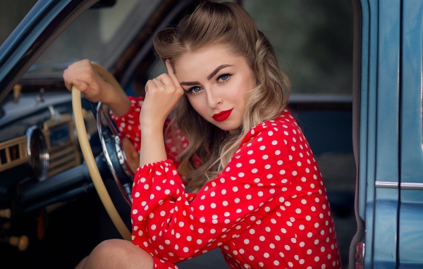 Голубоглазая ретро девушка за рулем автомобиля 