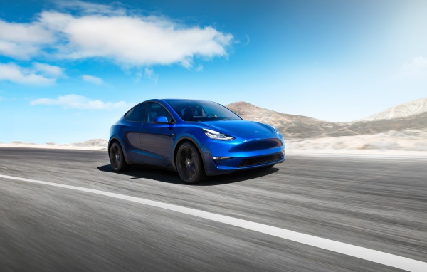 Синий автомобиль Tesla Model Y 2020 года на фоне голубого неба