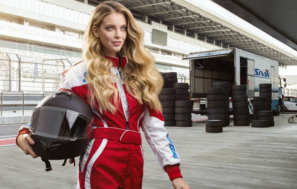 Девушка гонщица с шлемом в руках