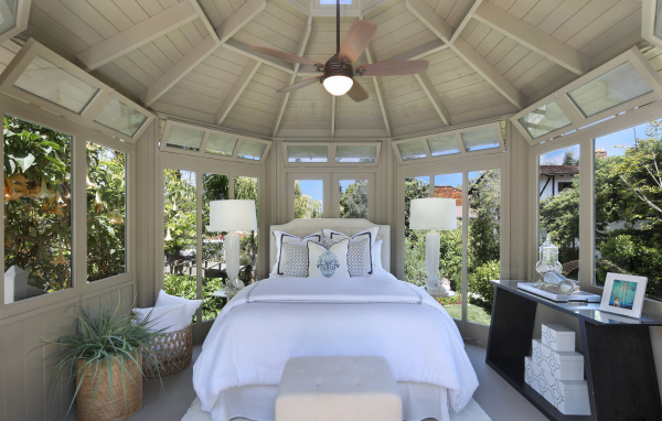 Большая спальная комната с окнами и белой кроватью 