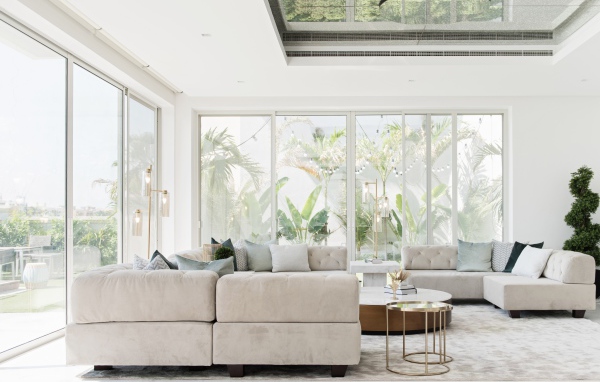 Большая гостиная комната с диваном и большими окнами