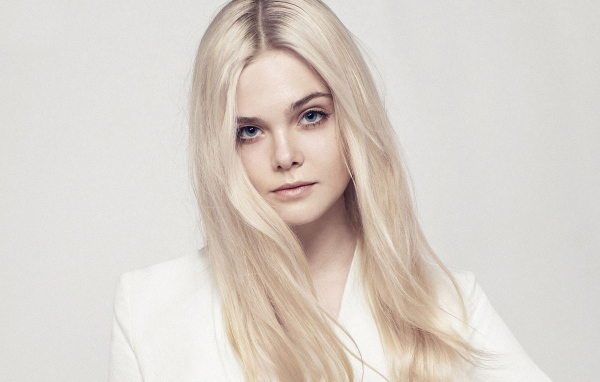 Длинноволосая актриса Эль Фэннинг на сером фоне