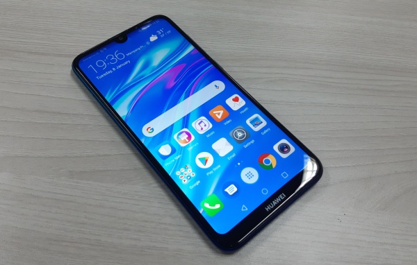 Смартфон Huawei Y7 Pro, 2019 года лежит на деревянном столе
