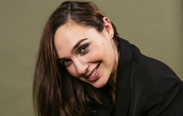 Улыбающаяся актриса Галь Гадот  в черном пиджаке