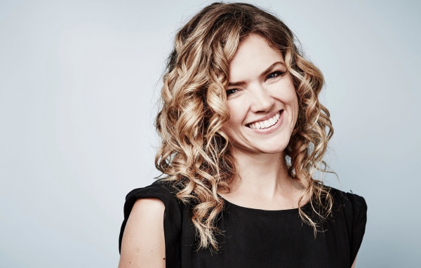 Улыбающаяся блондинка, актриса Эрин Ричардс на сером фоне