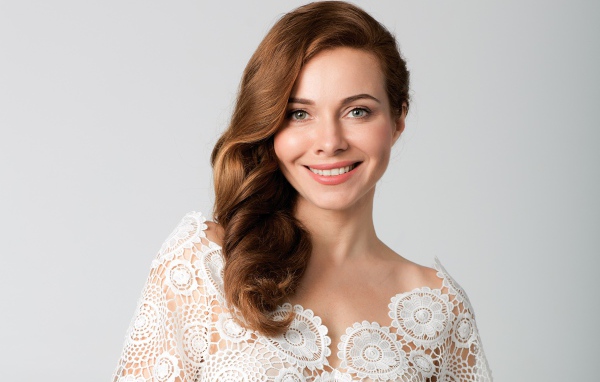 Улыбающаяся милая девушка, актриса Екатерина Гусева на сером фоне