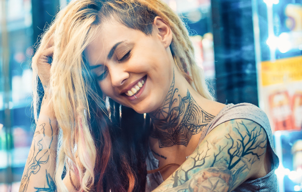 Улыбающаяся девушка с татуировками на теле